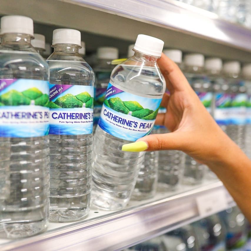 A woman choosing a bottle of Catherine's Peak water, one of Jamaica's best bottled water.