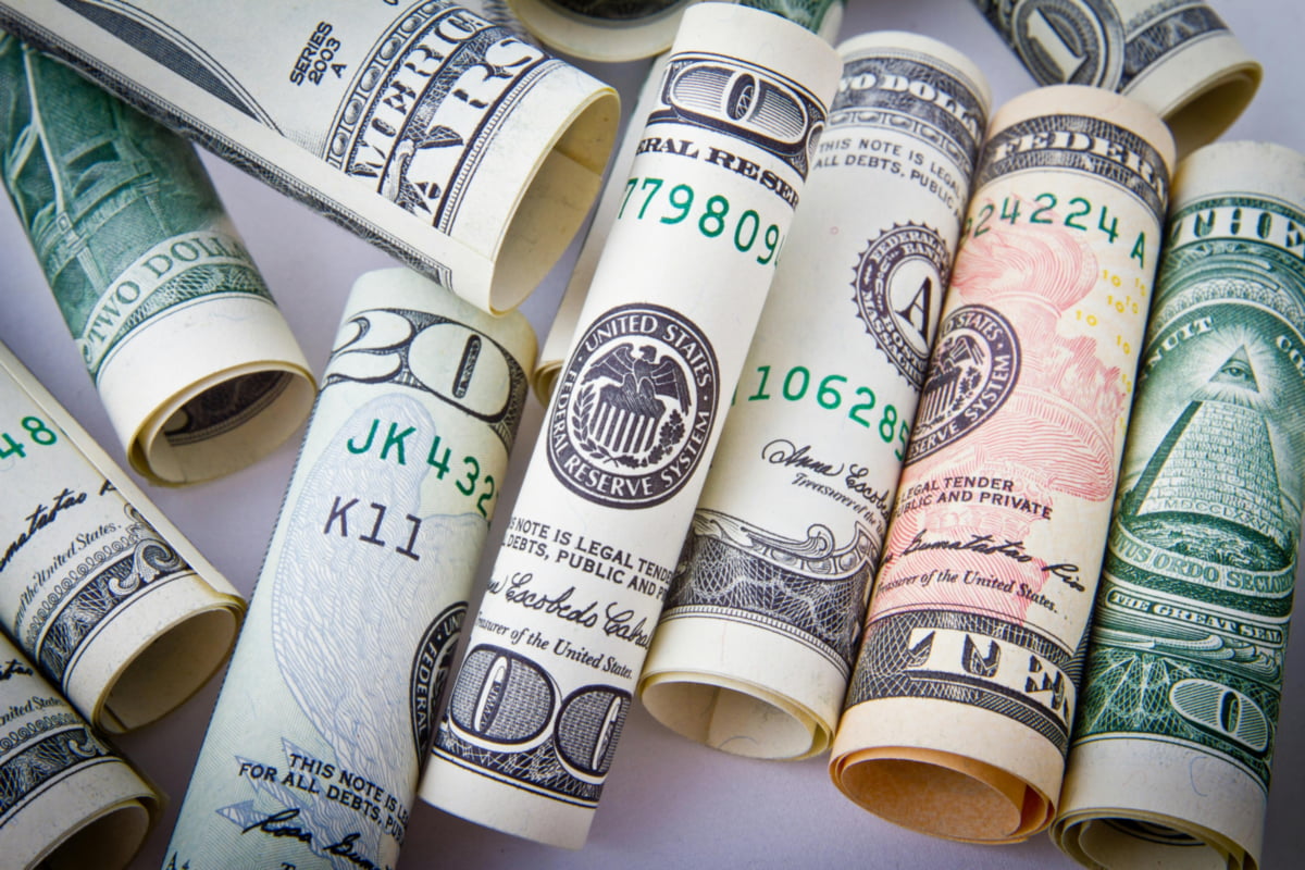 Rolled dollar bills showing travel money for Jamaica