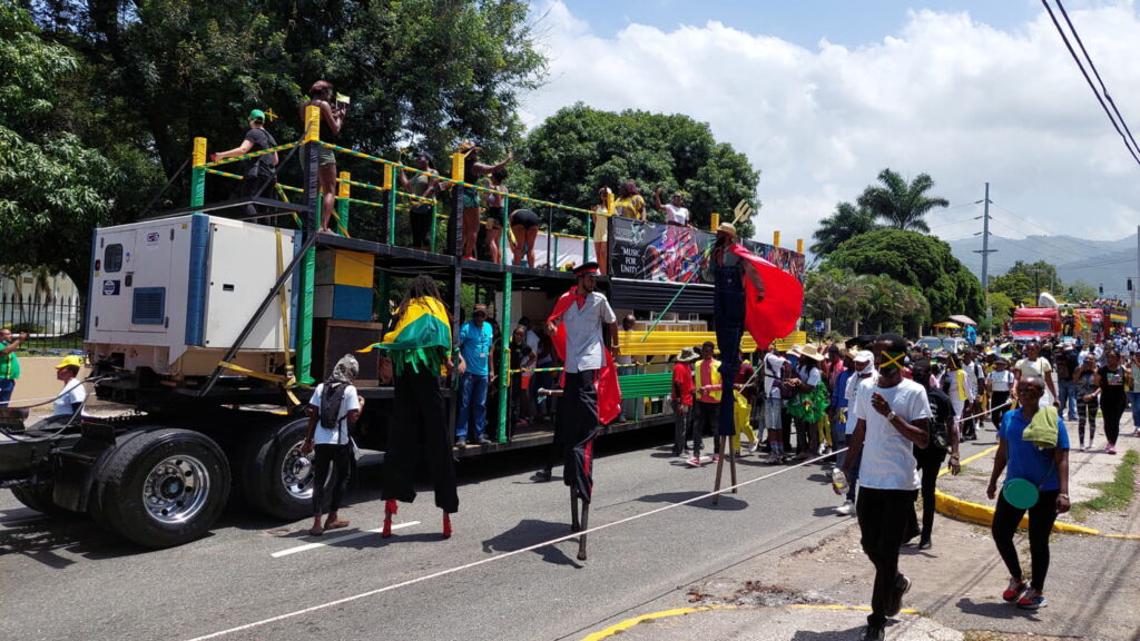 People walking with flags during Jamaica's Independence Day parade, showing their pride on this public holiday.