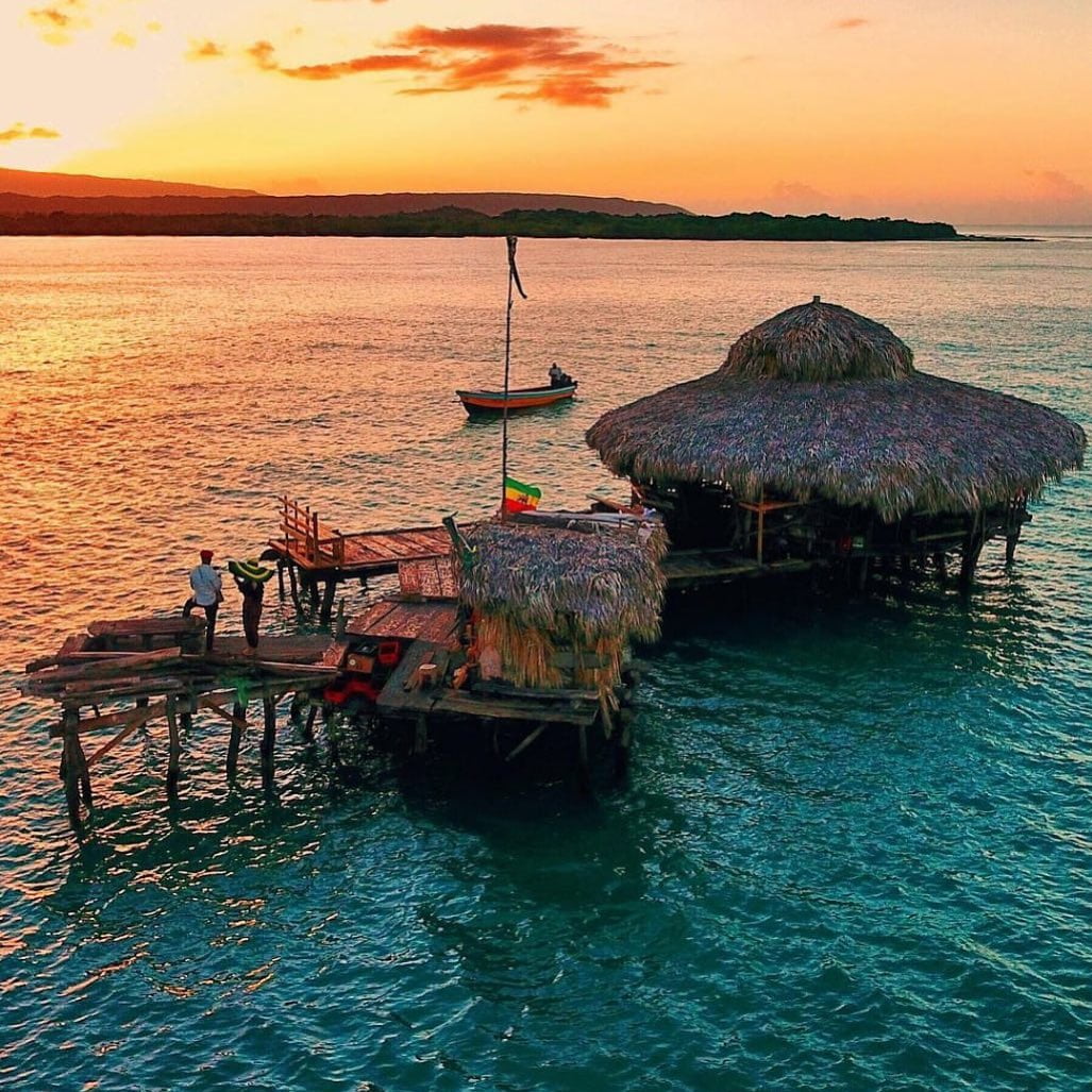 Aerial view of Floyd’s Pelican Bar surrounded by the Caribbean Sea at sunset.