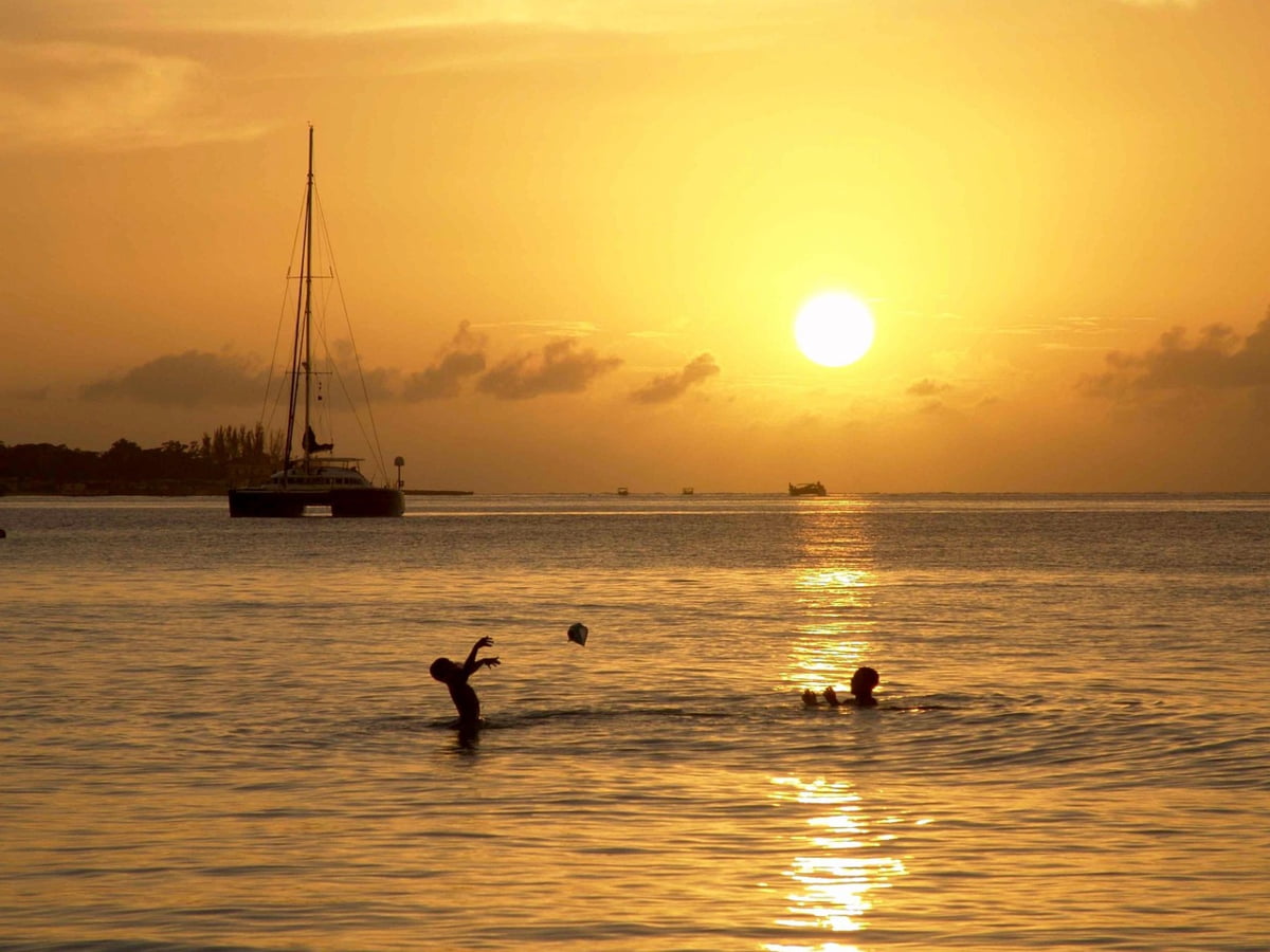 Two young boys playing in the water during a Negril sunset.